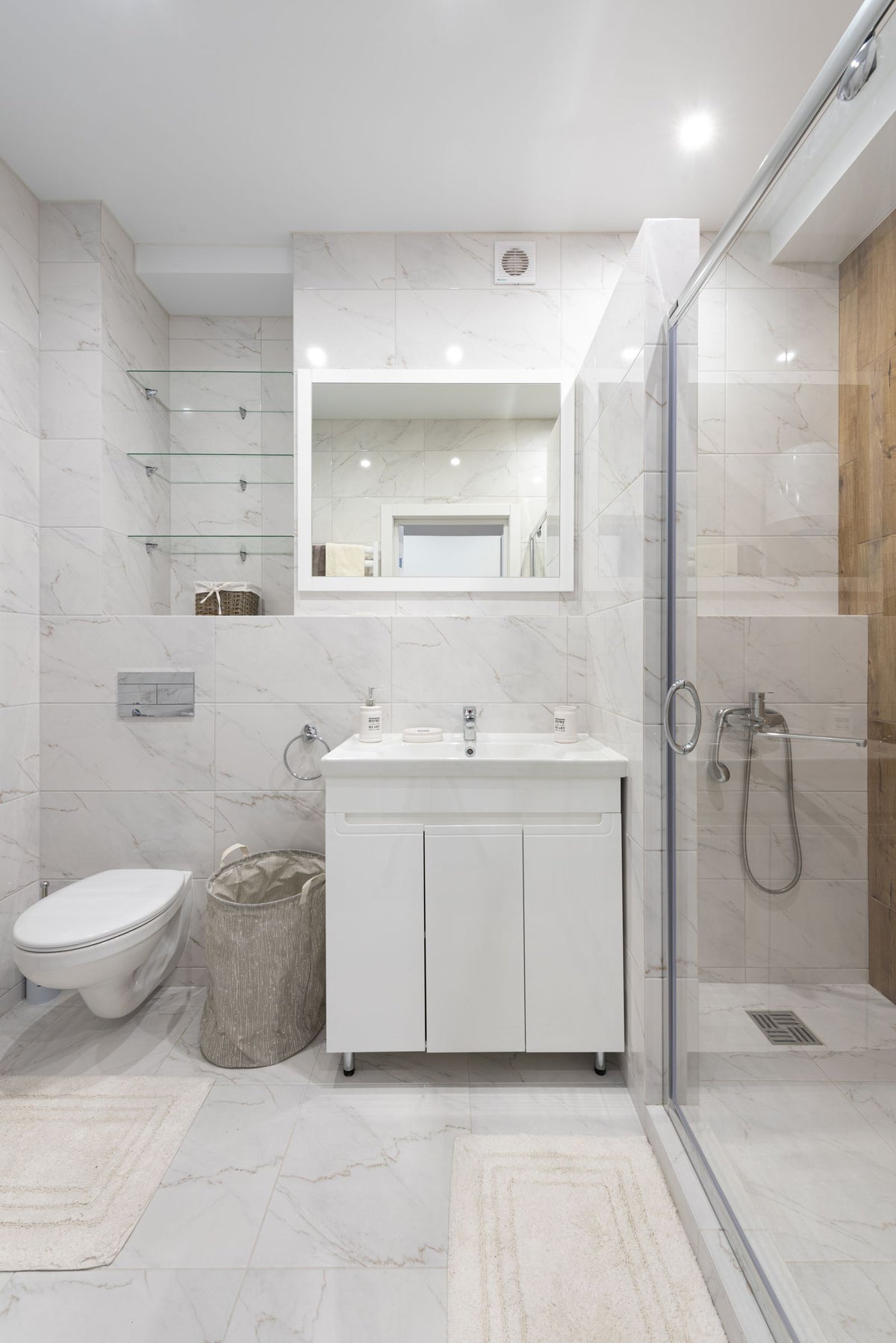 Moderne badkamer met marmeren wastafel, toilet en glazen douchecabine