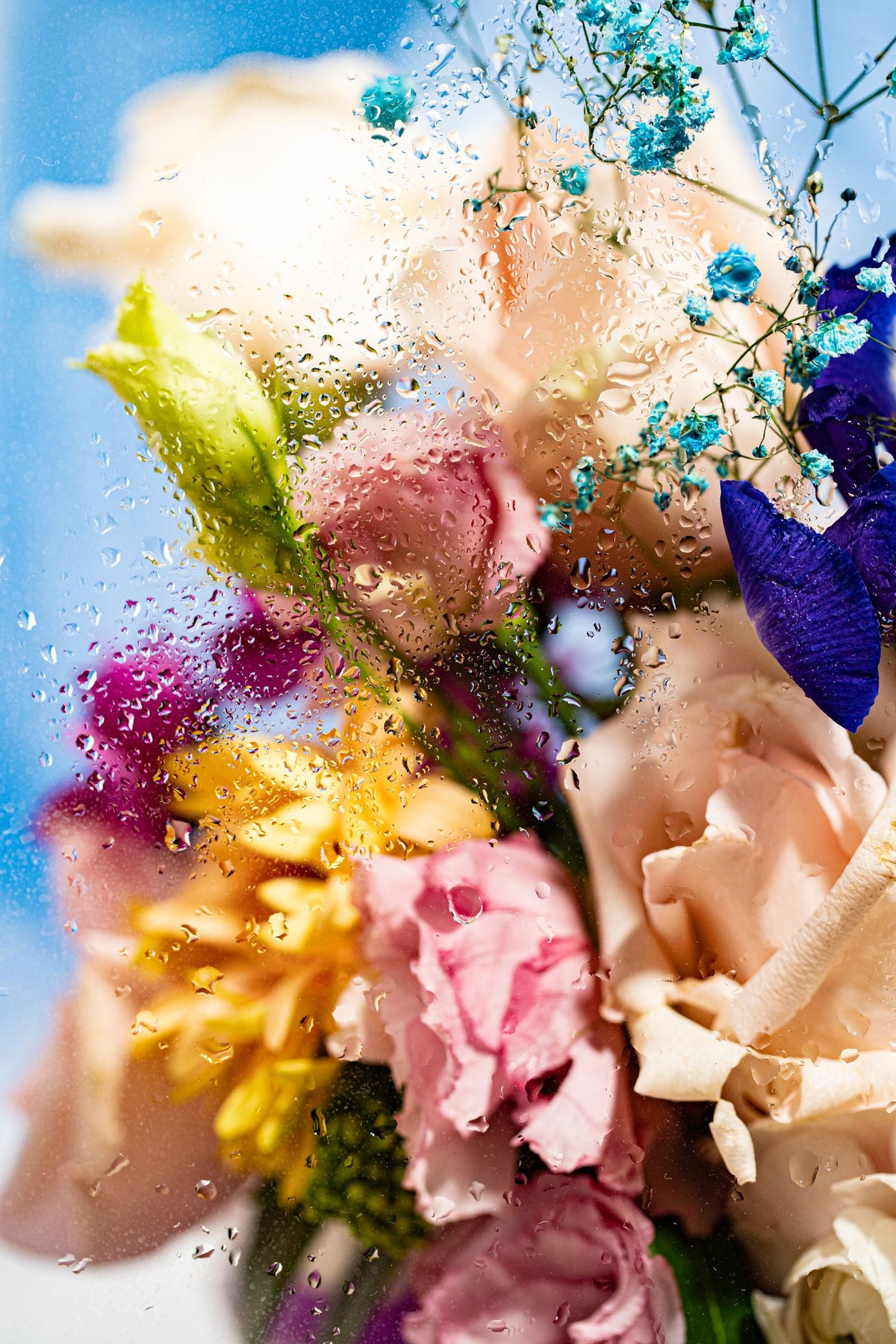 Boeket bloemen achter een nat raam